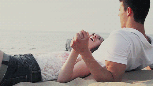 Playful Beach Couple Cuddling GIF