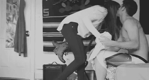 Man pulls woman on bed to cuddle gif