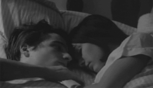 Man stares at his girlfriend and rubs her arm while sleeping gif