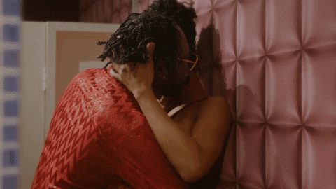 Passionate Kiss Against Pink Wall GIF