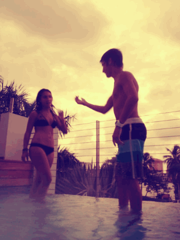 Playful Pool Splashing Couple GIF