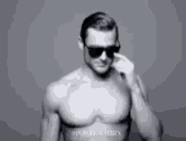 Sexy Smiling Man Adjusts Sunglasses GIF