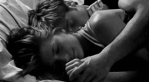 Woman opens her eyes and smiles while cuddling gif