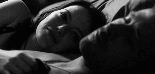 Woman stares at her man while he sleeps gif